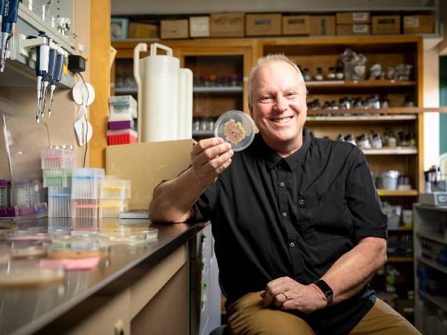 stories-freitag-640x480.jpg Michael Freitag in a lab, holding a clear round container with a specimen